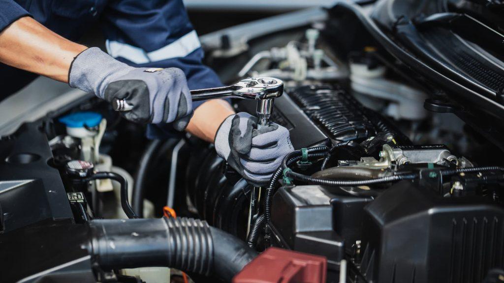 Professional mechanic working on the engine of the car in the garage. Car repair service