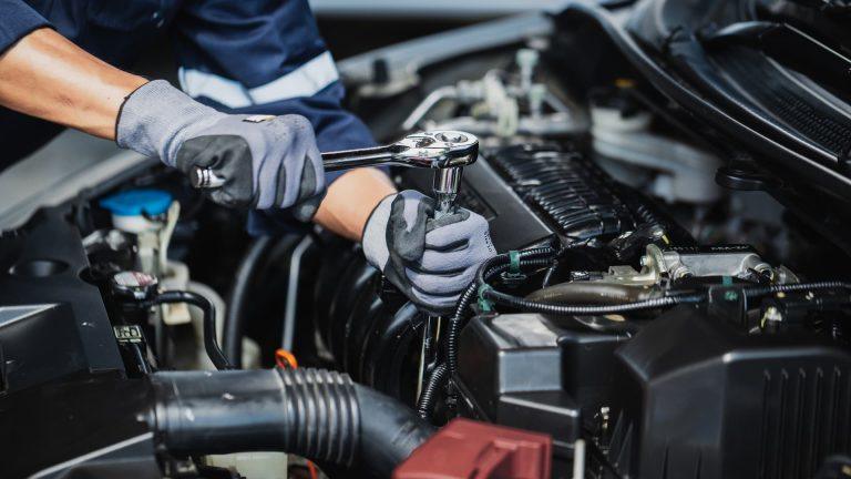 Professional mechanic working on the engine of the car in the garage. Car repair service